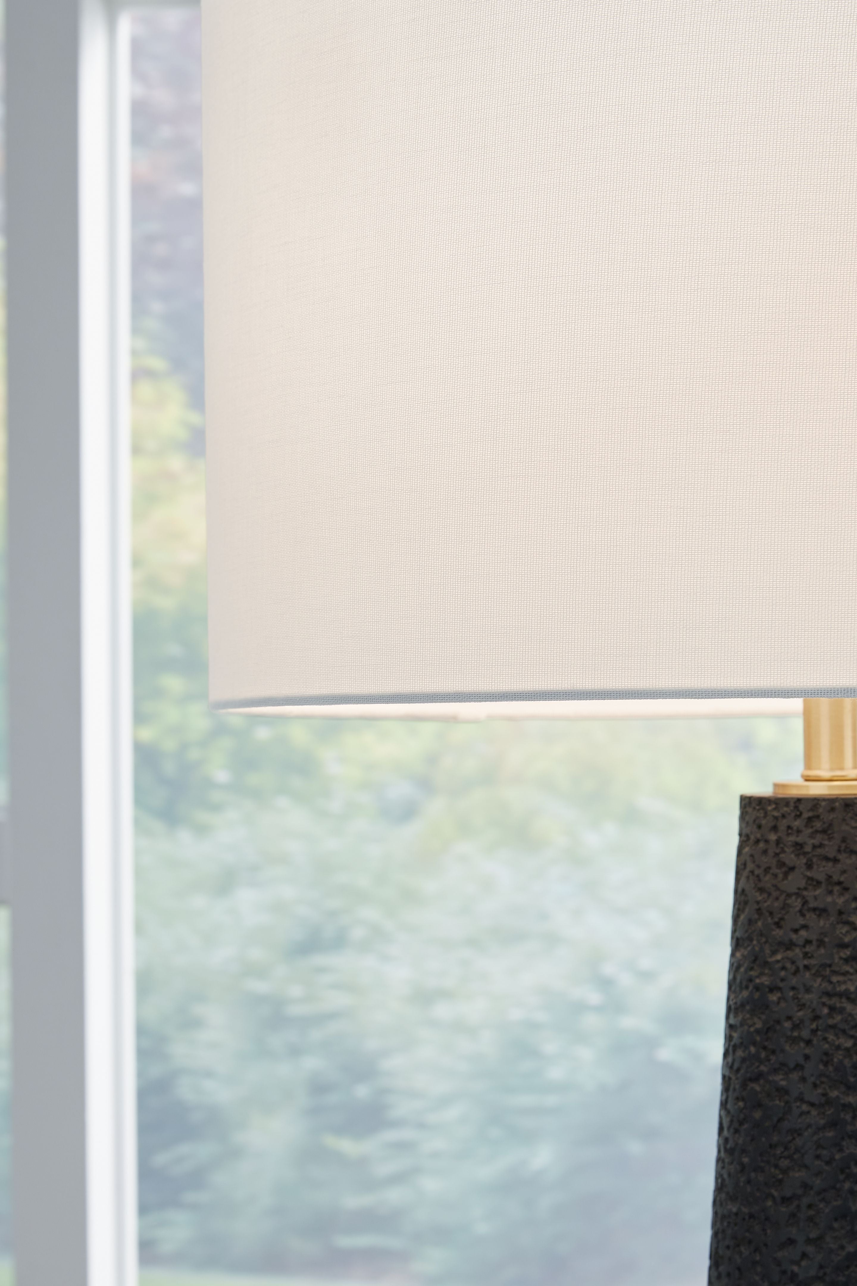 Black textured lamp body with brass collar and off-white shade edge