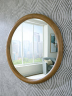 Yadiel brown oval accent mirror with wood-look frame, reflecting a window