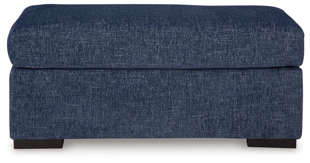 Dark blue upholstered ottoman with cushioned top and square frame