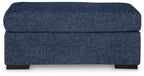 Dark blue upholstered ottoman with cushioned top and square frame