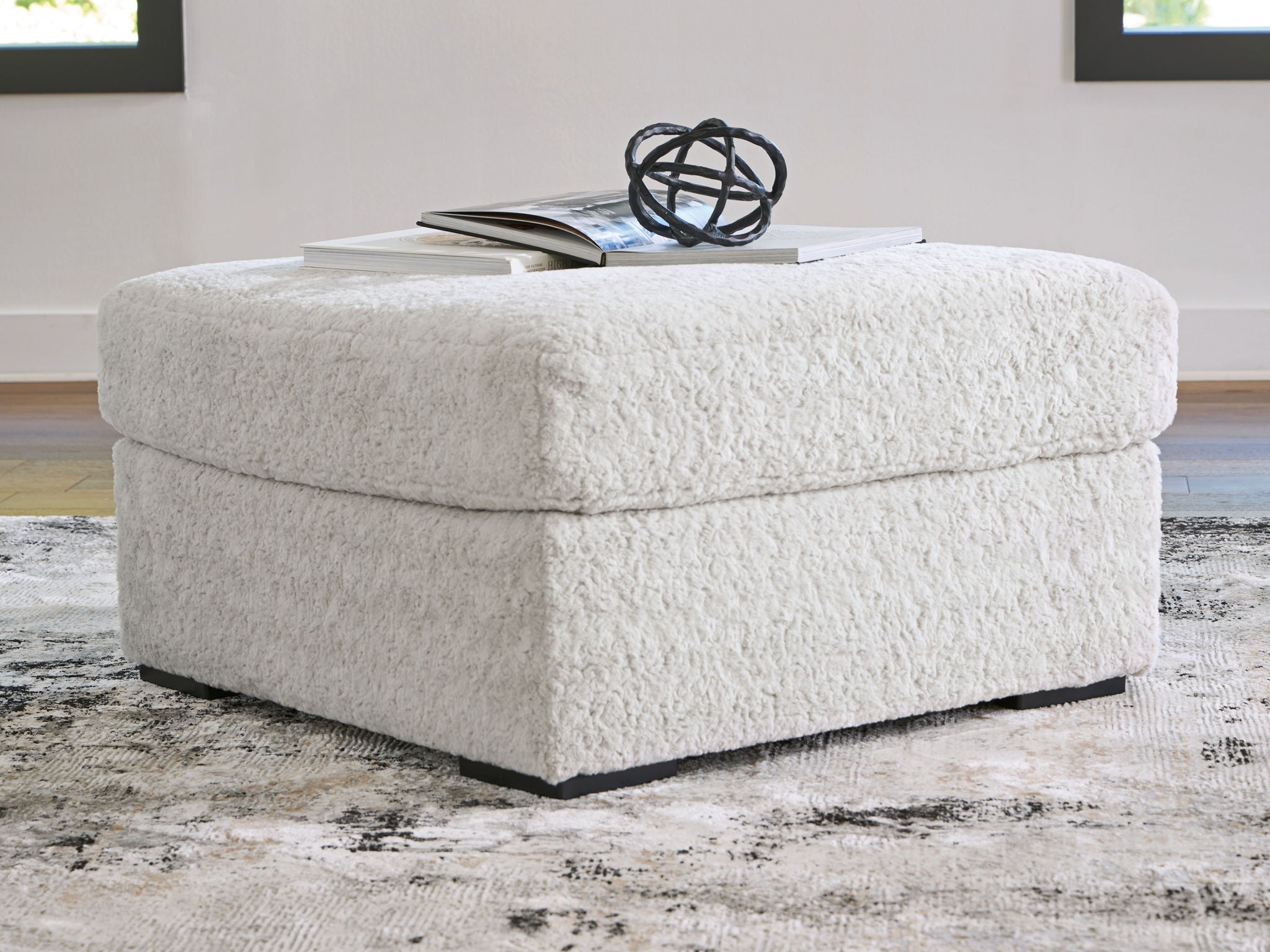 Light gray oversized accent ottoman with rounded top and black base feet