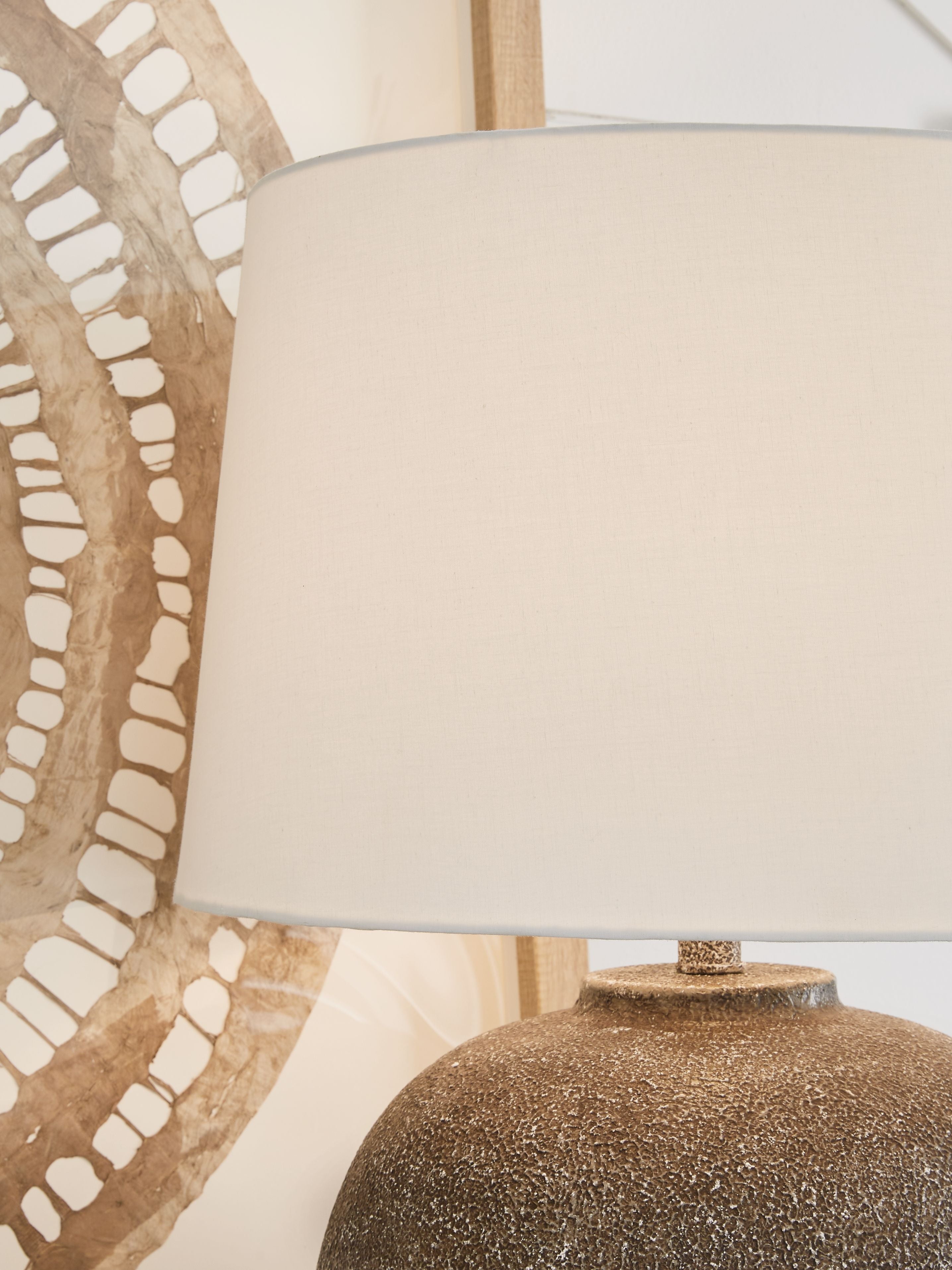 Antique brown metal table lamp with white shade and speckled round base
