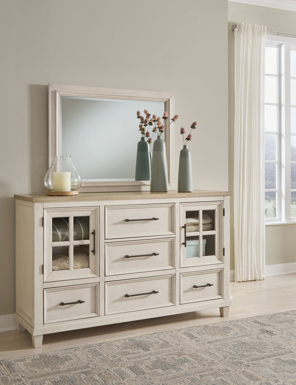 White dresser with paneled cabinet doors and matching wall mirror