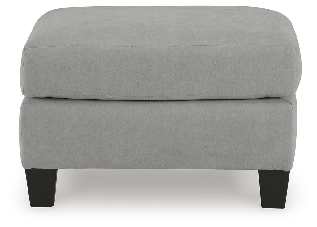 Gray upholstered ottoman with blocky profile and dark legs, front view
