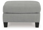 Gray upholstered ottoman with blocky profile and dark legs, front view