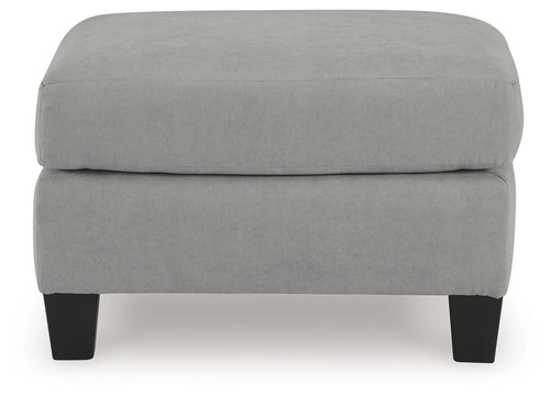 Gray upholstered ottoman with blocky profile and dark legs, front view