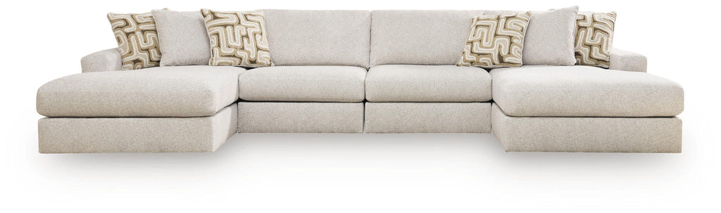 Light beige sectional sofa with multiple seat sections and patterned throw pillows.