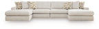 Light beige sectional sofa with multiple seat sections and patterned throw pillows.