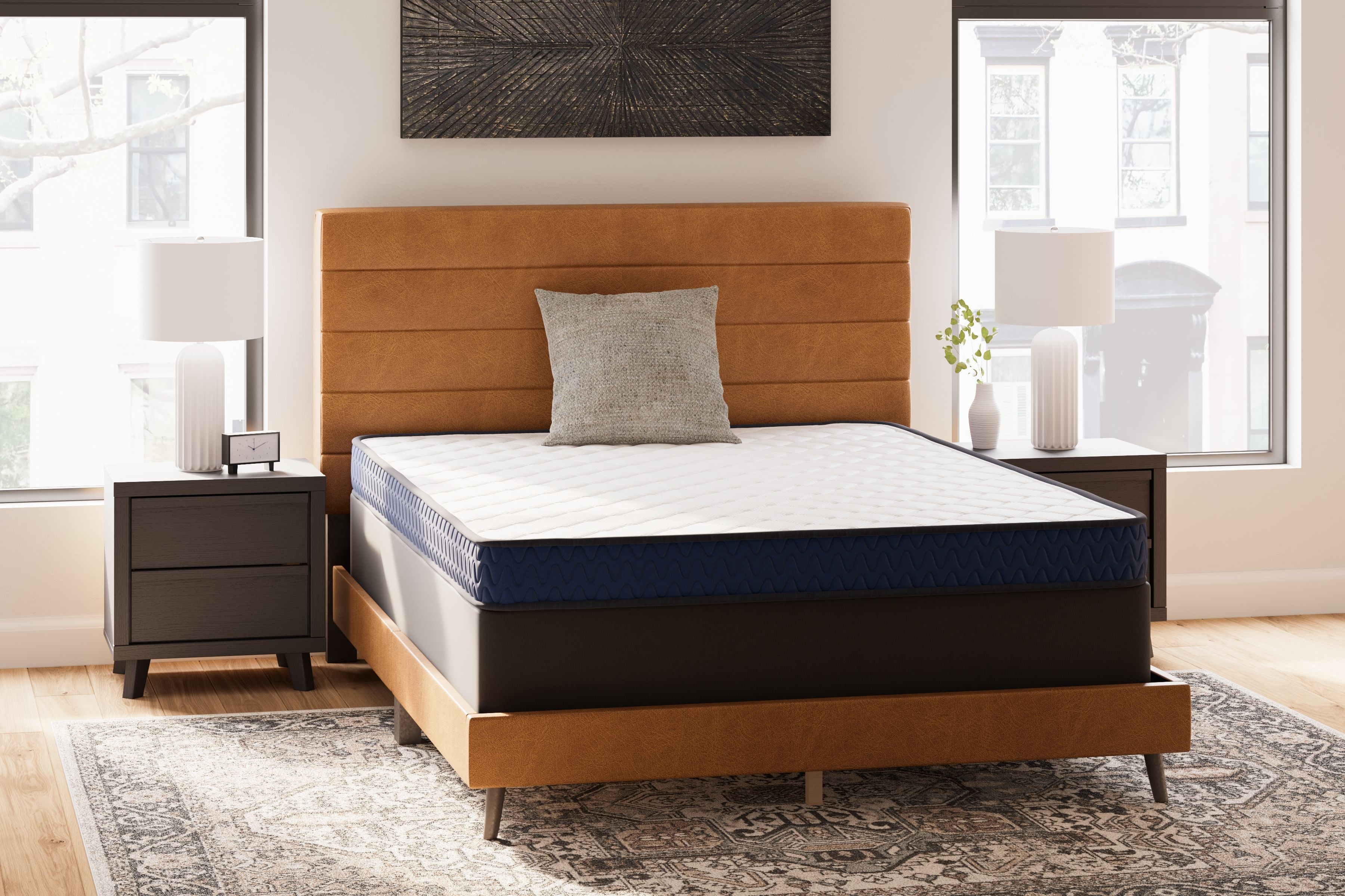 Firm mattress with white top and dark blue sides on a dark wood bed frame