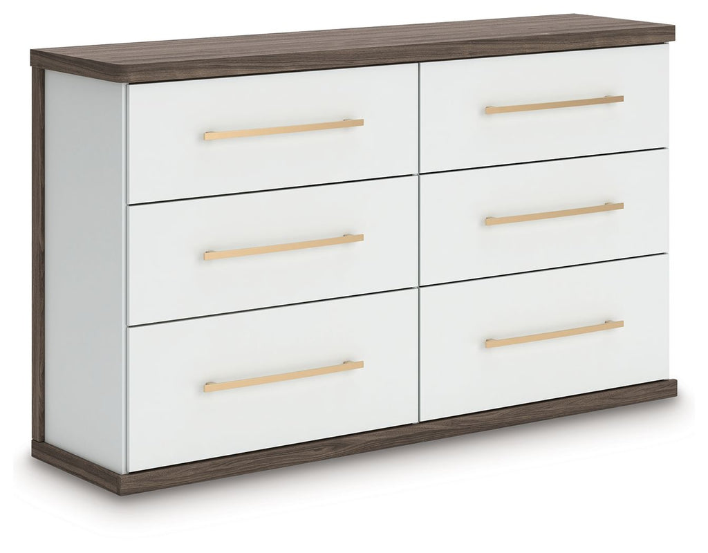 Six-drawer dresser with white drawers and warm wood top, featuring gold bar pulls.