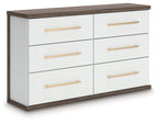 Six-drawer dresser with white drawers and warm wood top, featuring gold bar pulls.