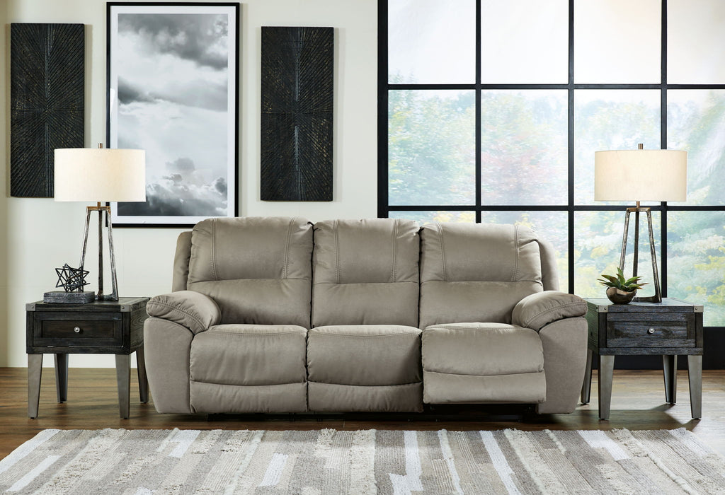 Reclining sofa in light putty gray upholstery with padded arms and plush seat cushions