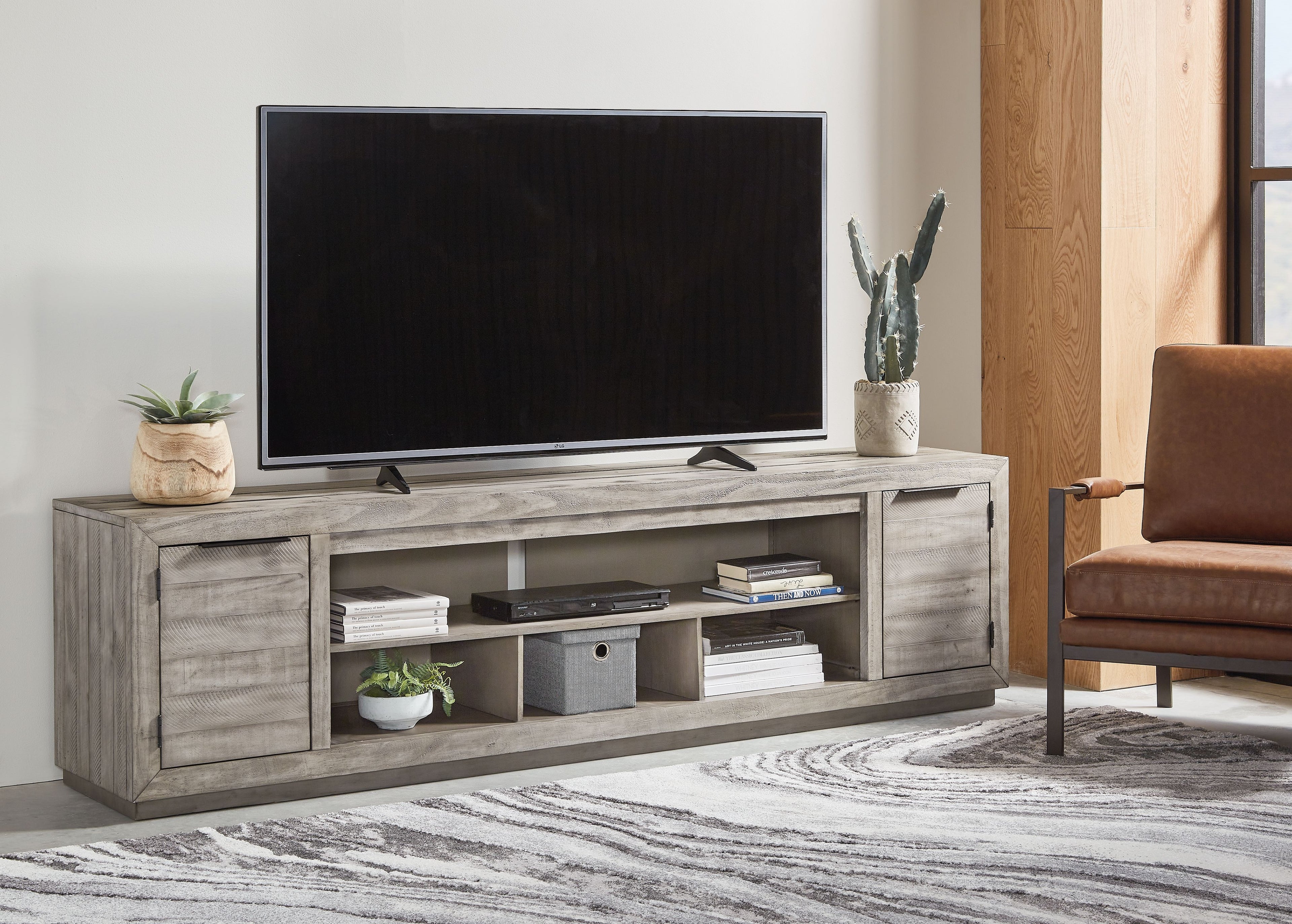 Gray TV stand with open center shelves, two drawers, and media storage