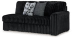 Dark velvet right-facing sofa with ribbed arms and back, plus two throw pillows
