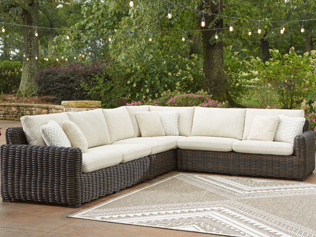 Outdoor sectional sofa with dark brown wicker and beige cushions, shown on patio