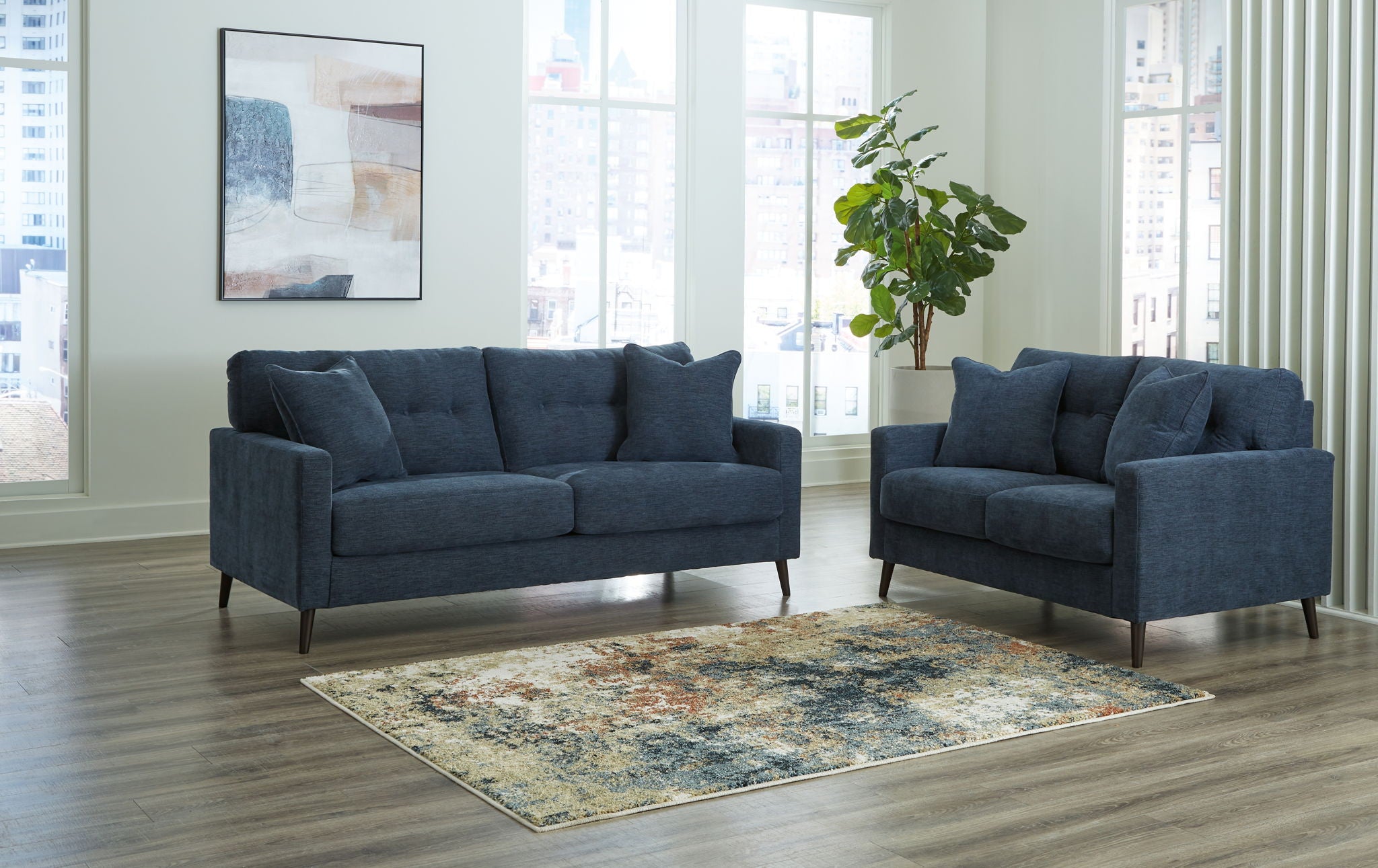 Blue upholstered sofa set with two matching seating pieces and four throw pillows