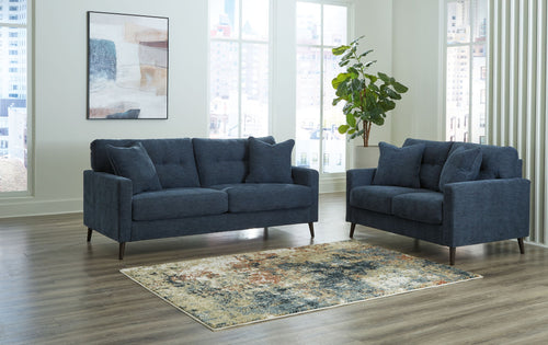 Blue upholstered sofa set with two matching seating pieces and four throw pillows