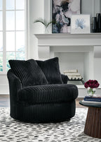 Swivel chair in dark ribbed fabric with two back cushions and curved armrests