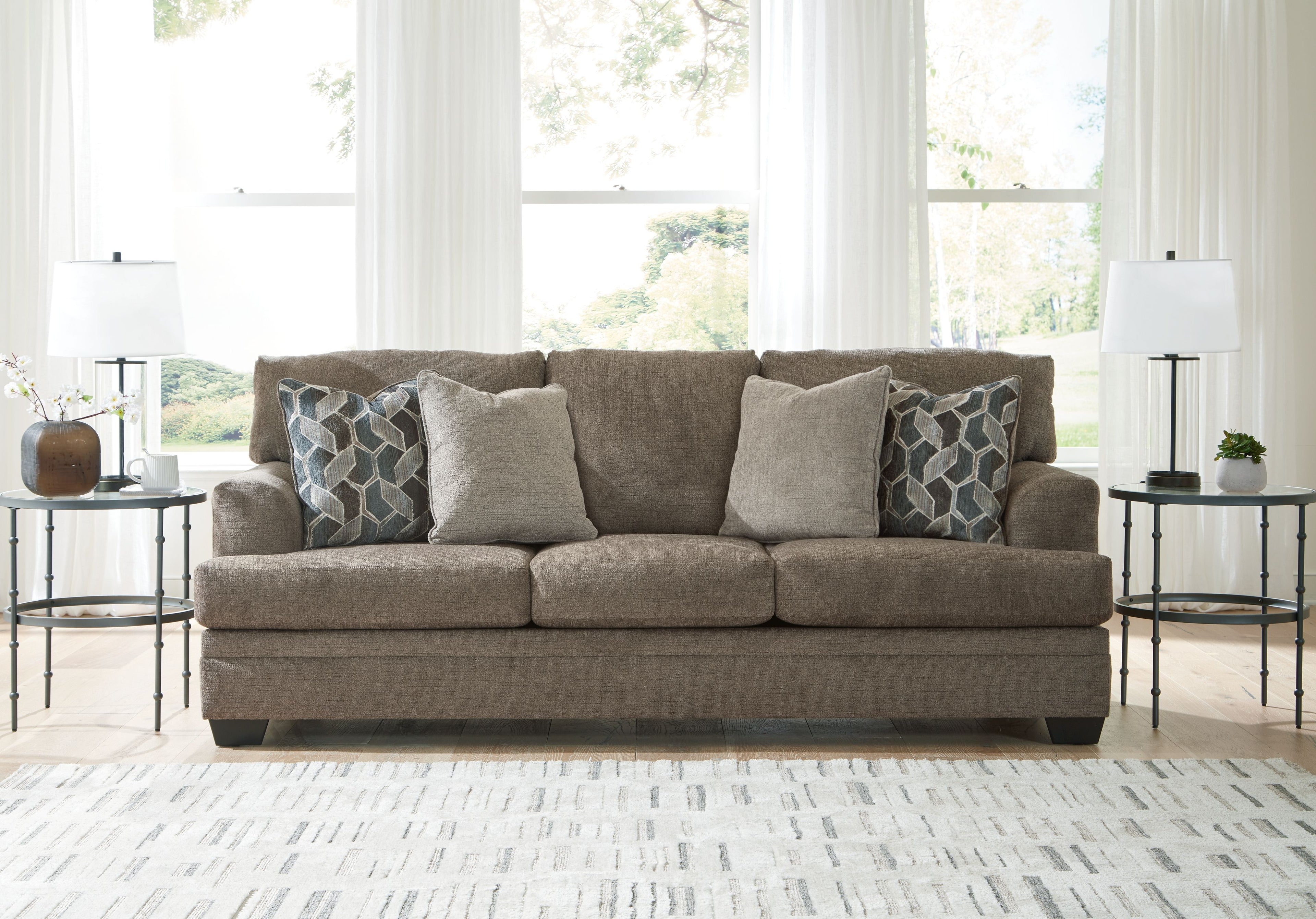 Stonemeade sofa in dark taupe with four accent pillows, including two geometric cushions