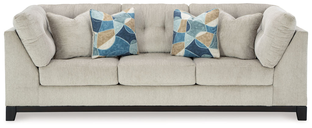 Stone fabric sofa with tufted arms and two decorative geometric throw pillows