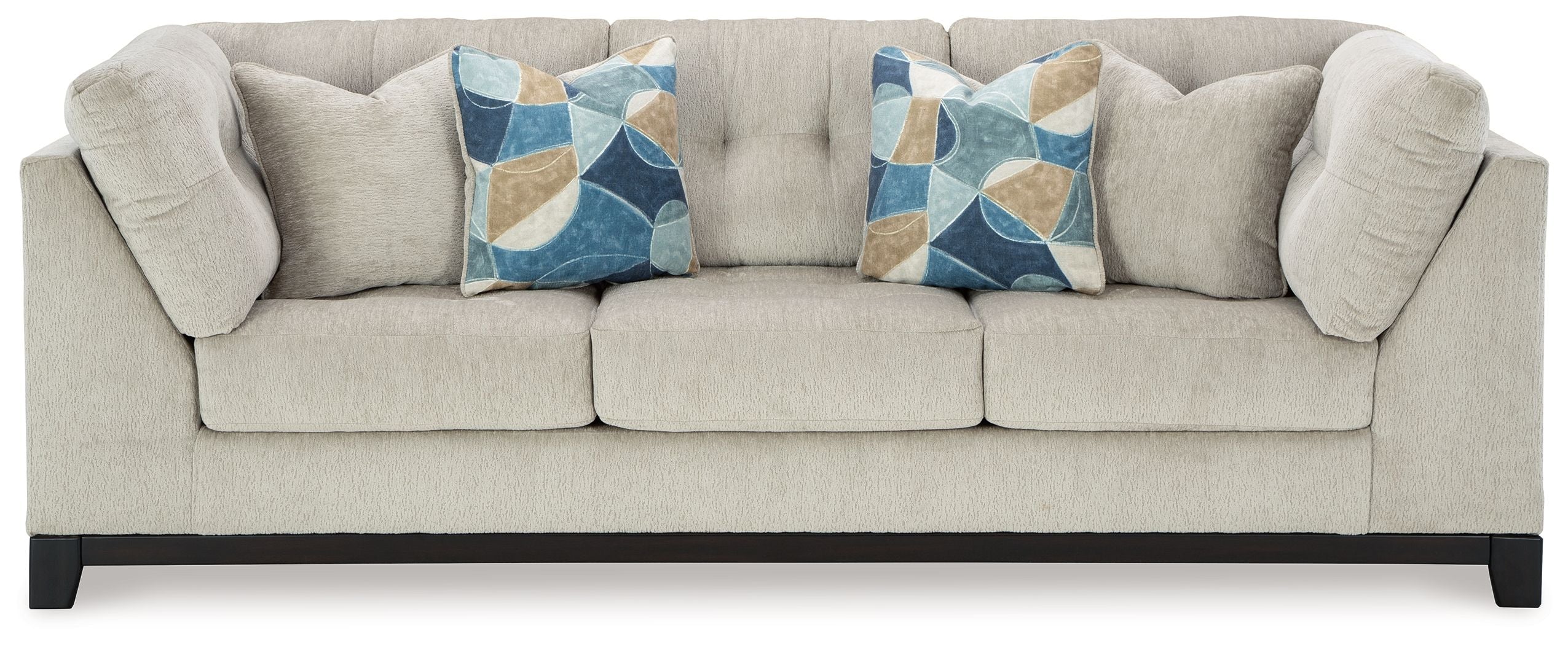 Stone fabric sofa with tufted arms and two decorative geometric throw pillows
