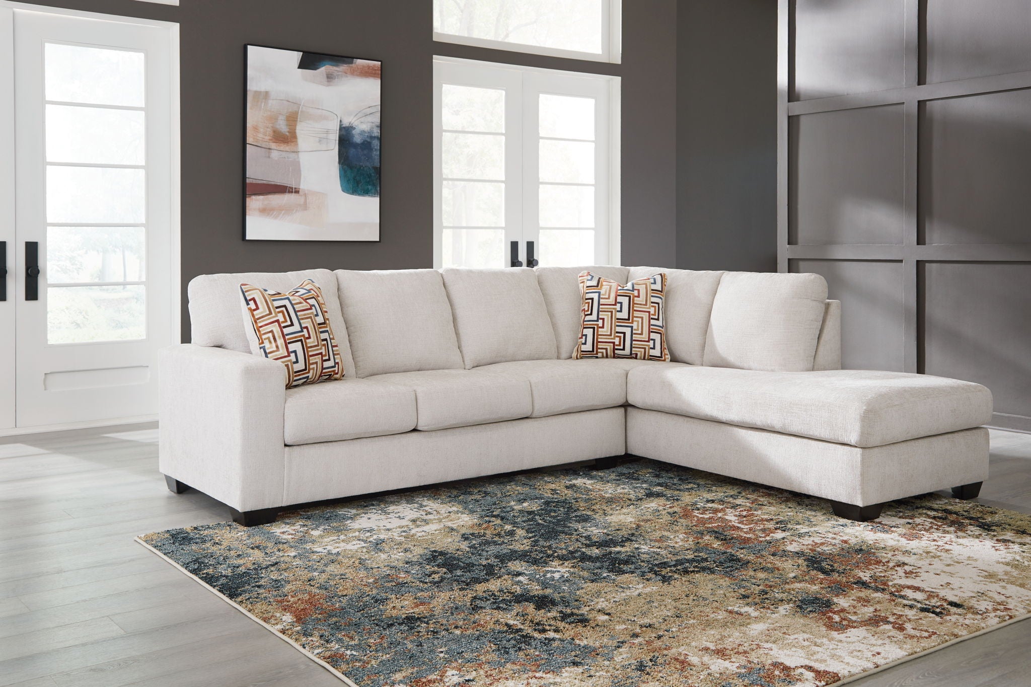 Light beige sectional sofa set with patterned pillows and corner chaise ottoman