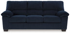 Blue upholstered sofa with padded armrests, tufted back cushions, and square legs.