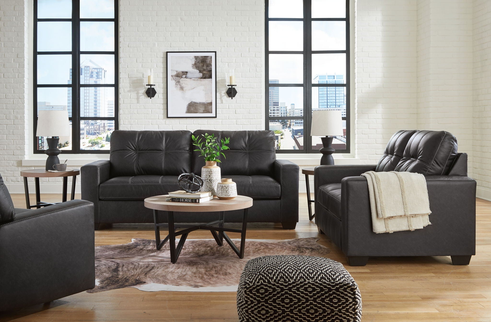 Black leather-look sofa with tufted back and matching recliner chair