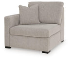 Grey upholstered corner chair with tall back and seat cushion, black feet