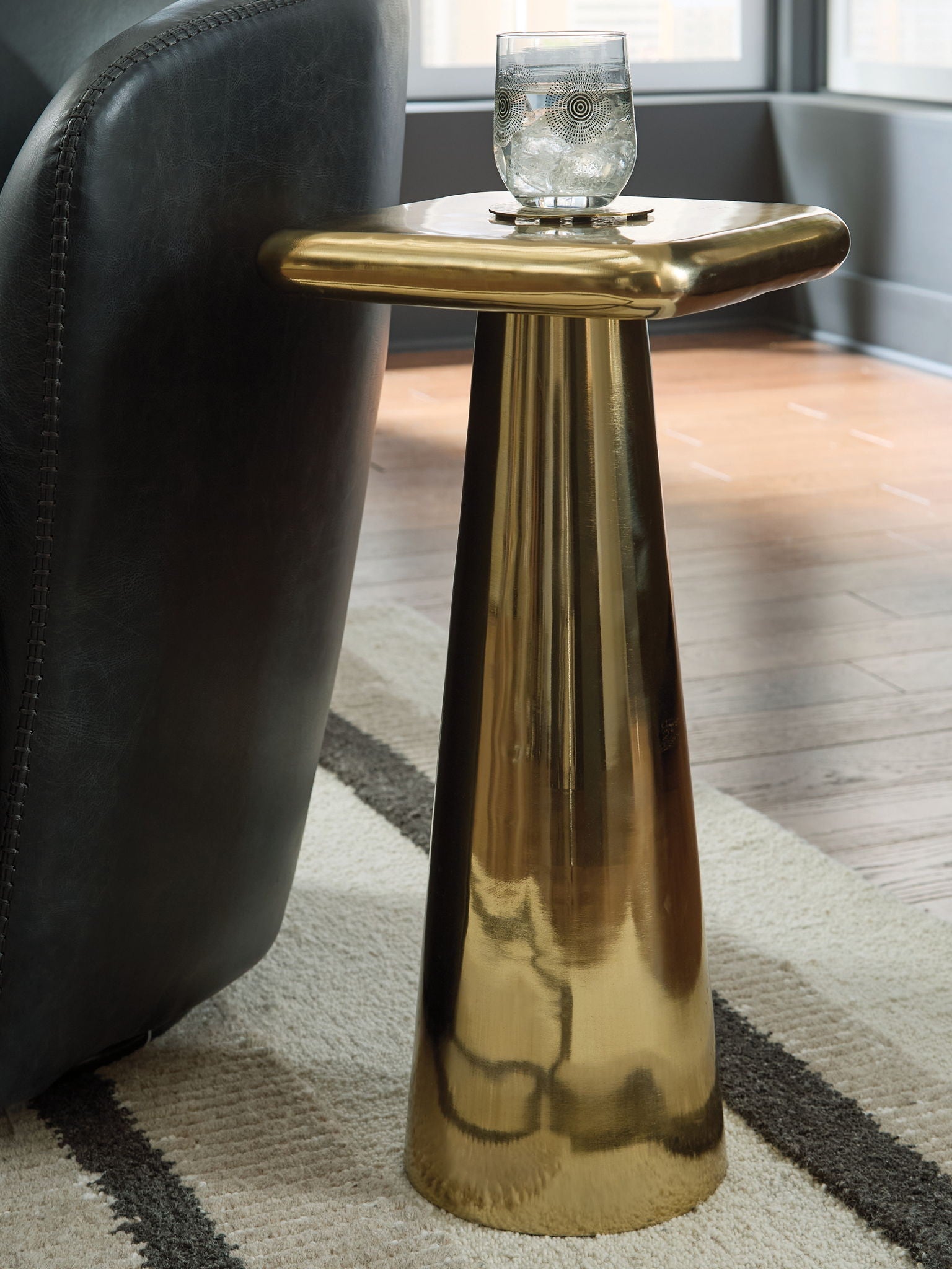 Gold accent table with rounded top and tall fluted pedestal base
