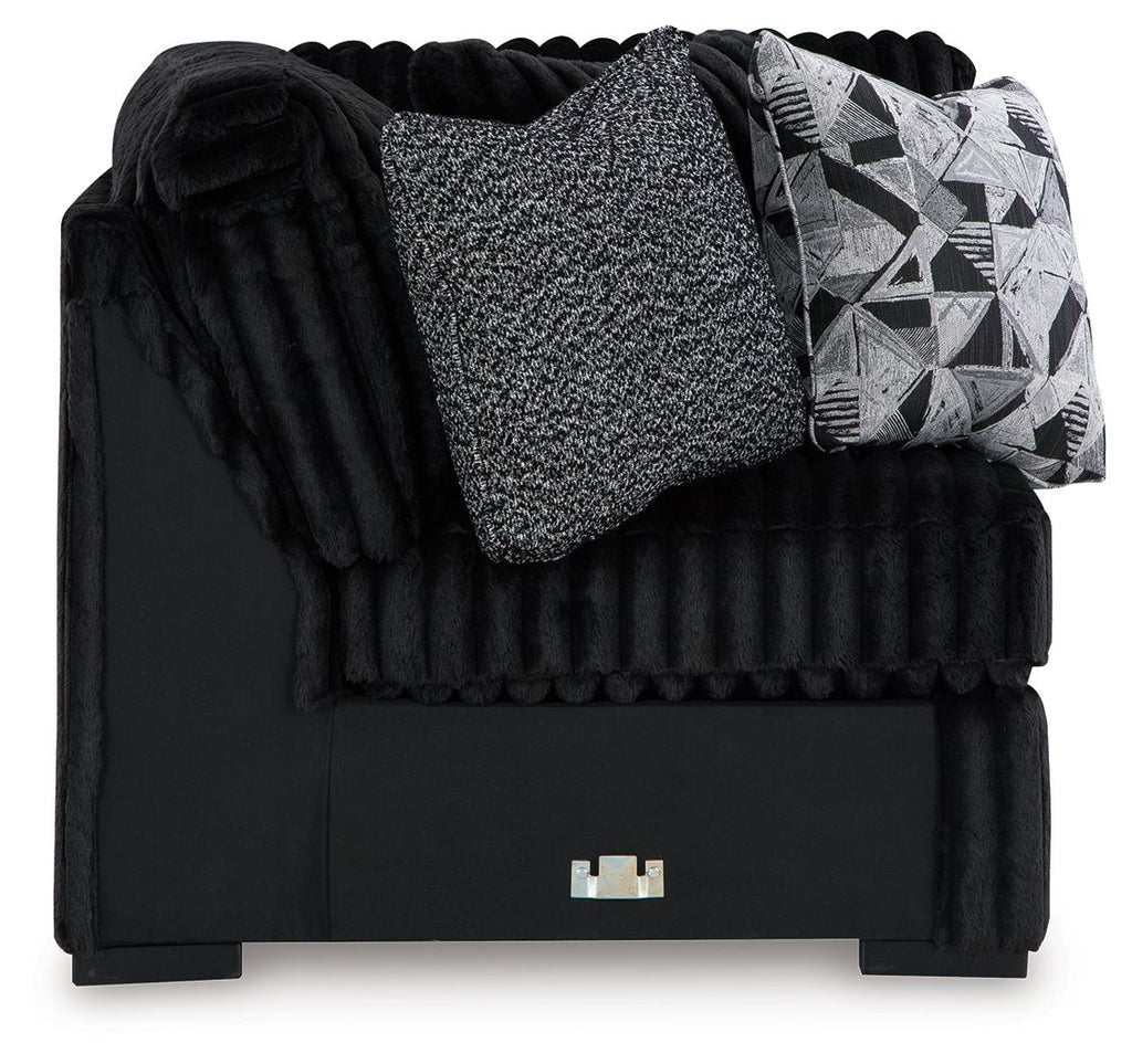 Black wedge sofa with ribbed texture, gray throw cushion and geometric pillow