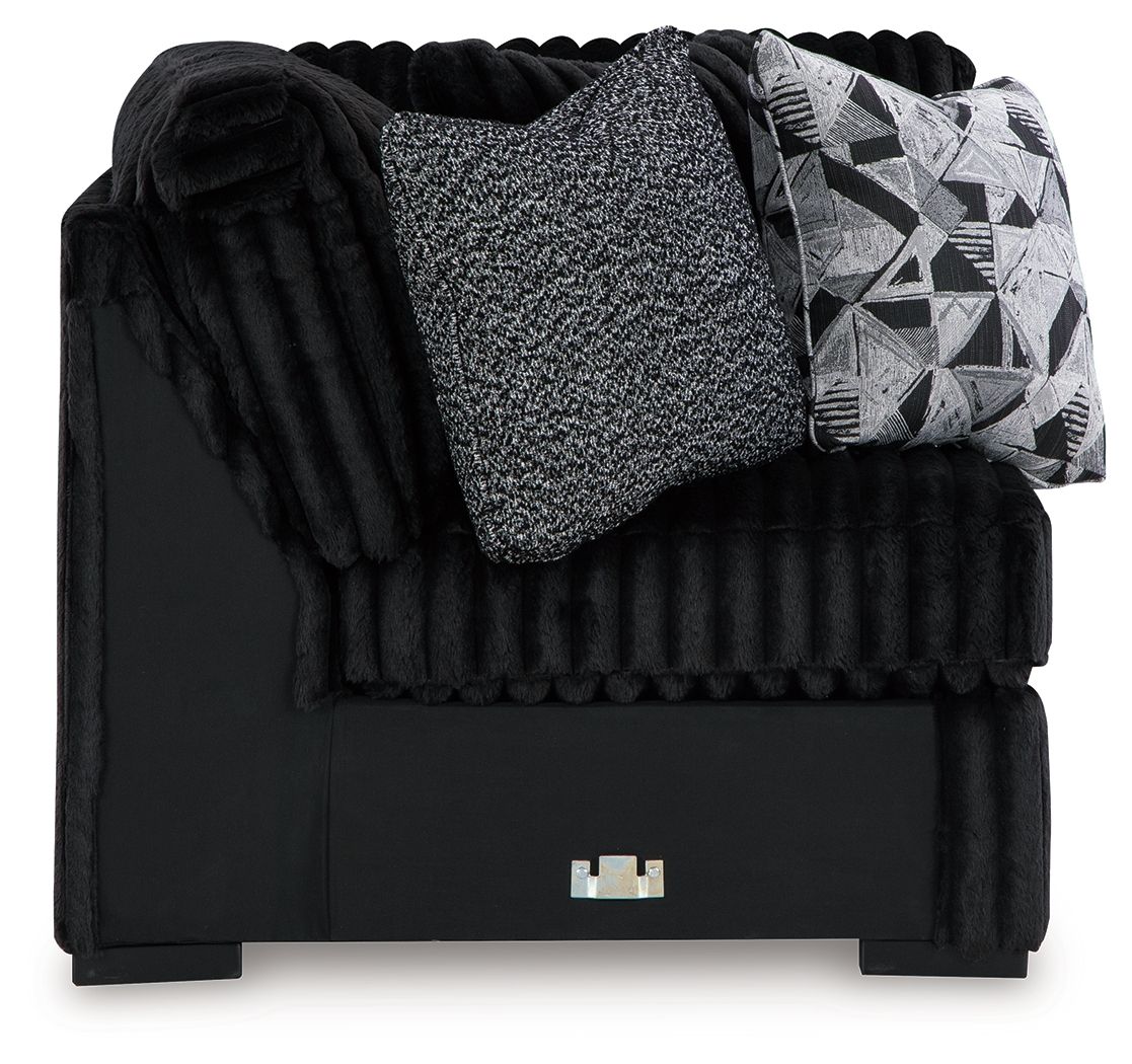 Black wedge sofa with ribbed texture, gray throw cushion and geometric pillow