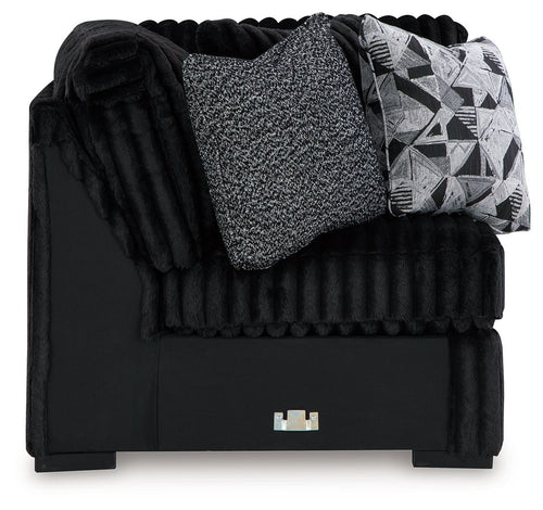 Black wedge sofa with ribbed texture, gray throw cushion and geometric pillow