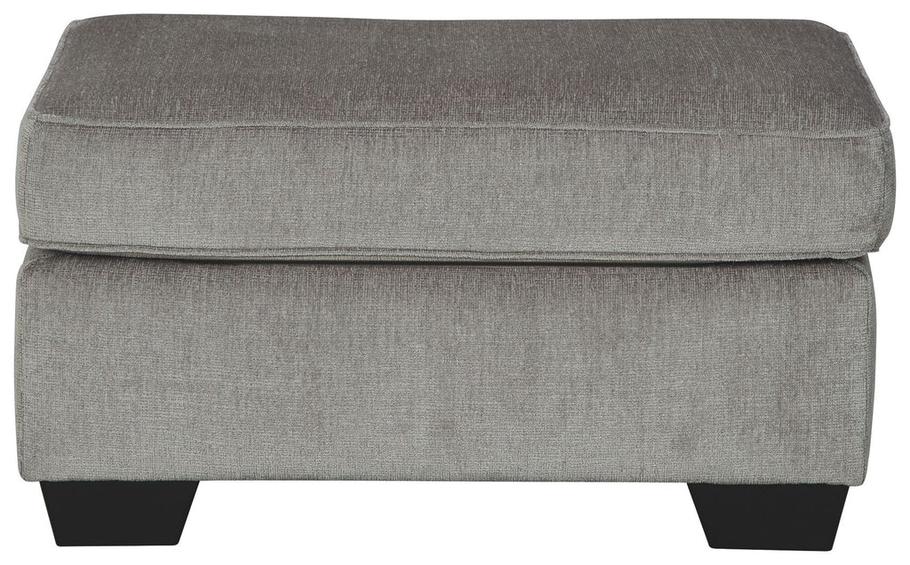 Light gray upholstered ottoman with cushioned top and squared sides