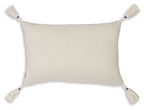 Light beige lumbar pillow with white tassel trim and smooth textured fabric
