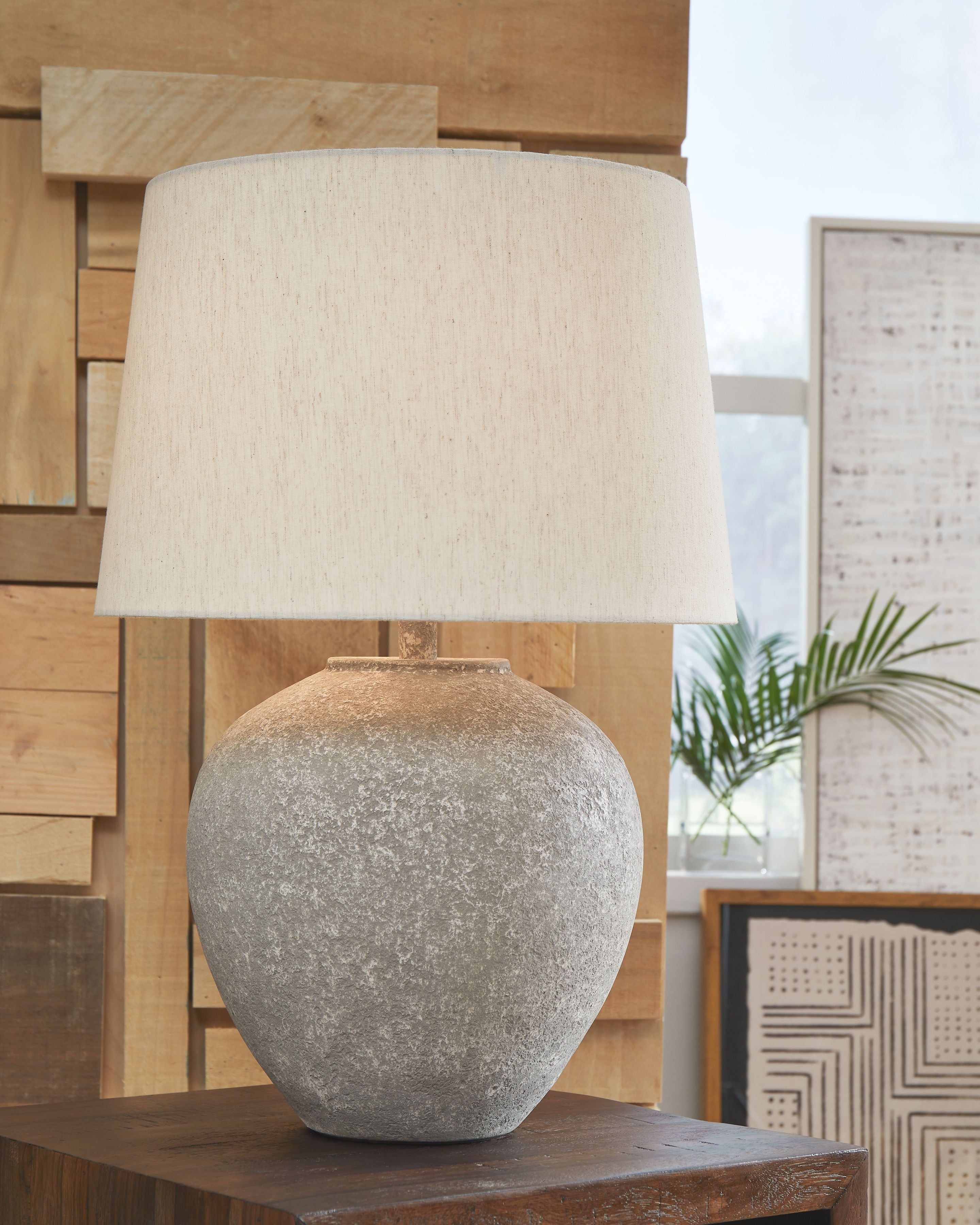 Paper table lamp with beige drum shade and distressed gray rounded base