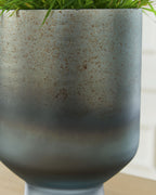 Blue speckled vase with flared rim, close-up view of curved body.