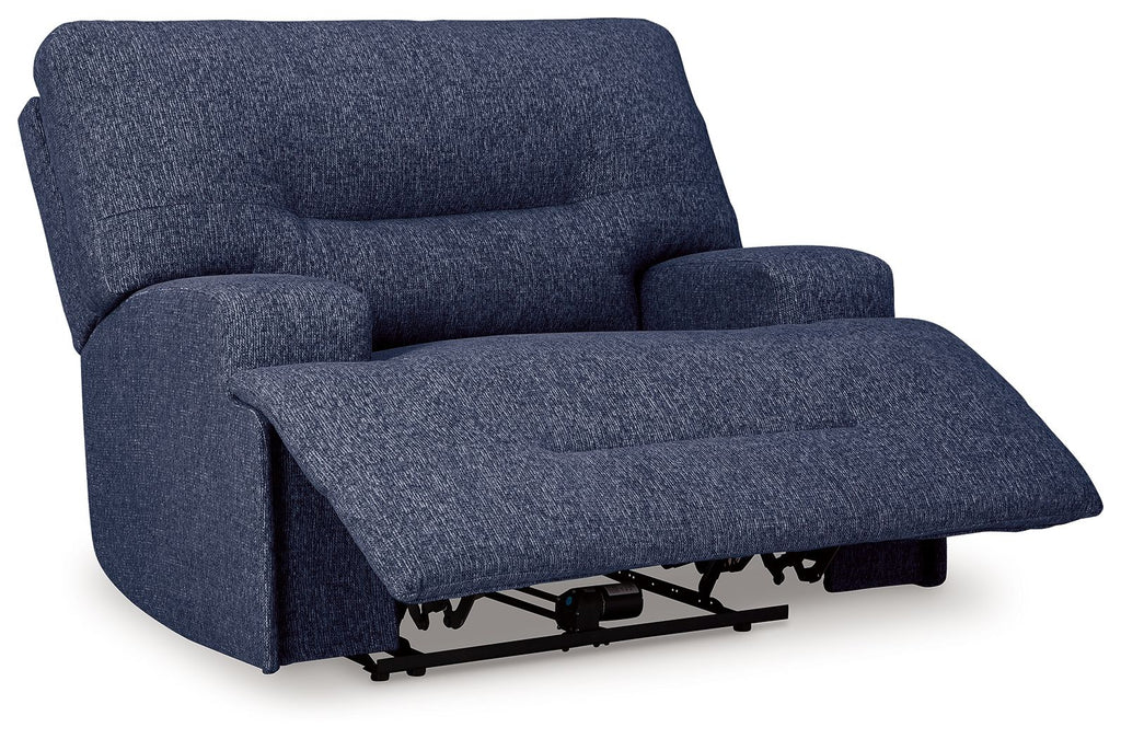 Wide seat power recliner in navy blue with extended footrest on power base.
