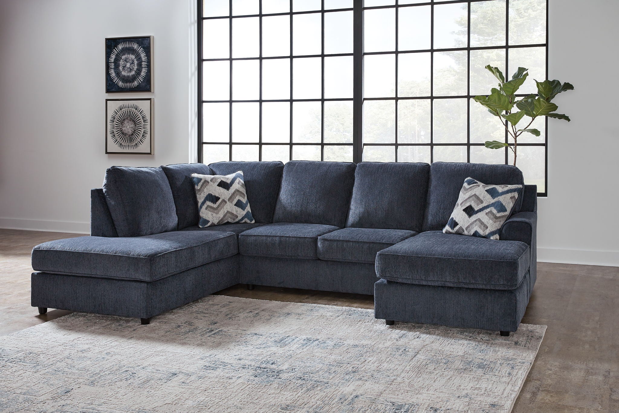 Blue sectional sofa with chaise and ottoman, patterned throw pillows
