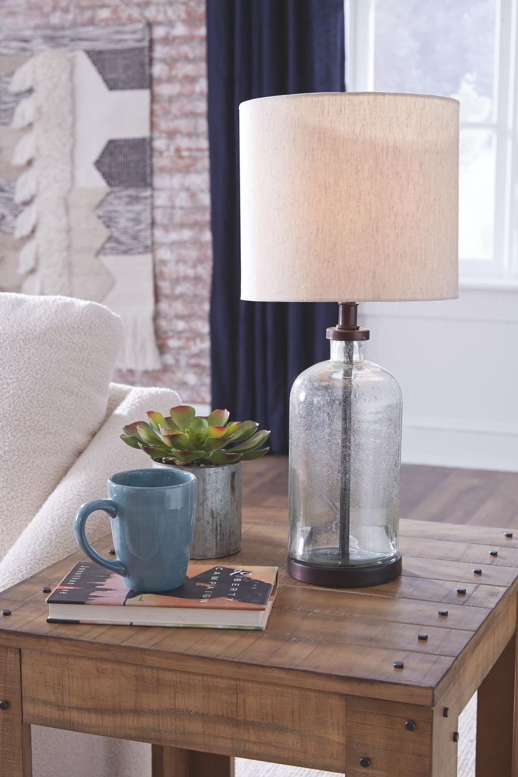 Clear glass table lamp with beige shade and bronze pedestal base