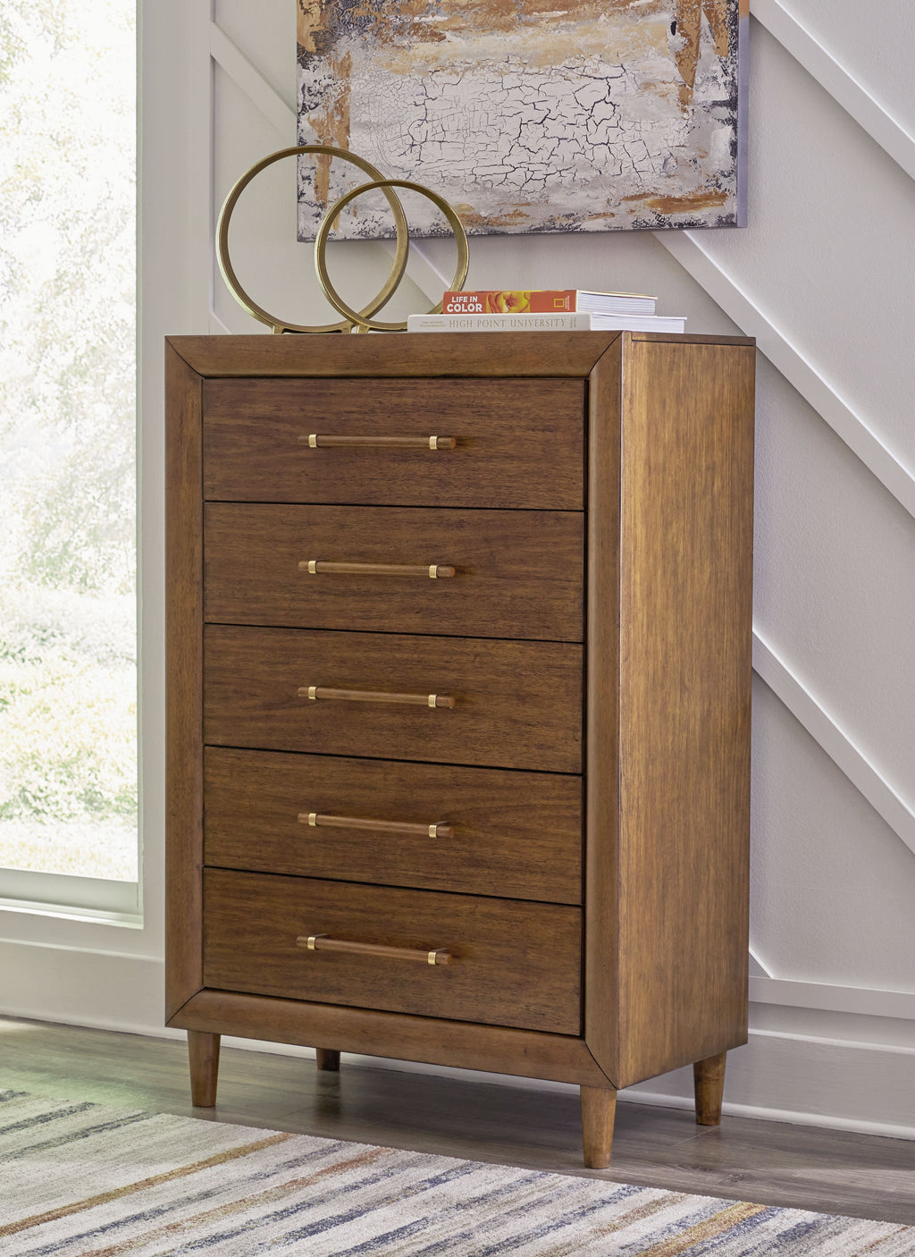 Lyncott brown five-drawer chest with long metal handles and tapered legs