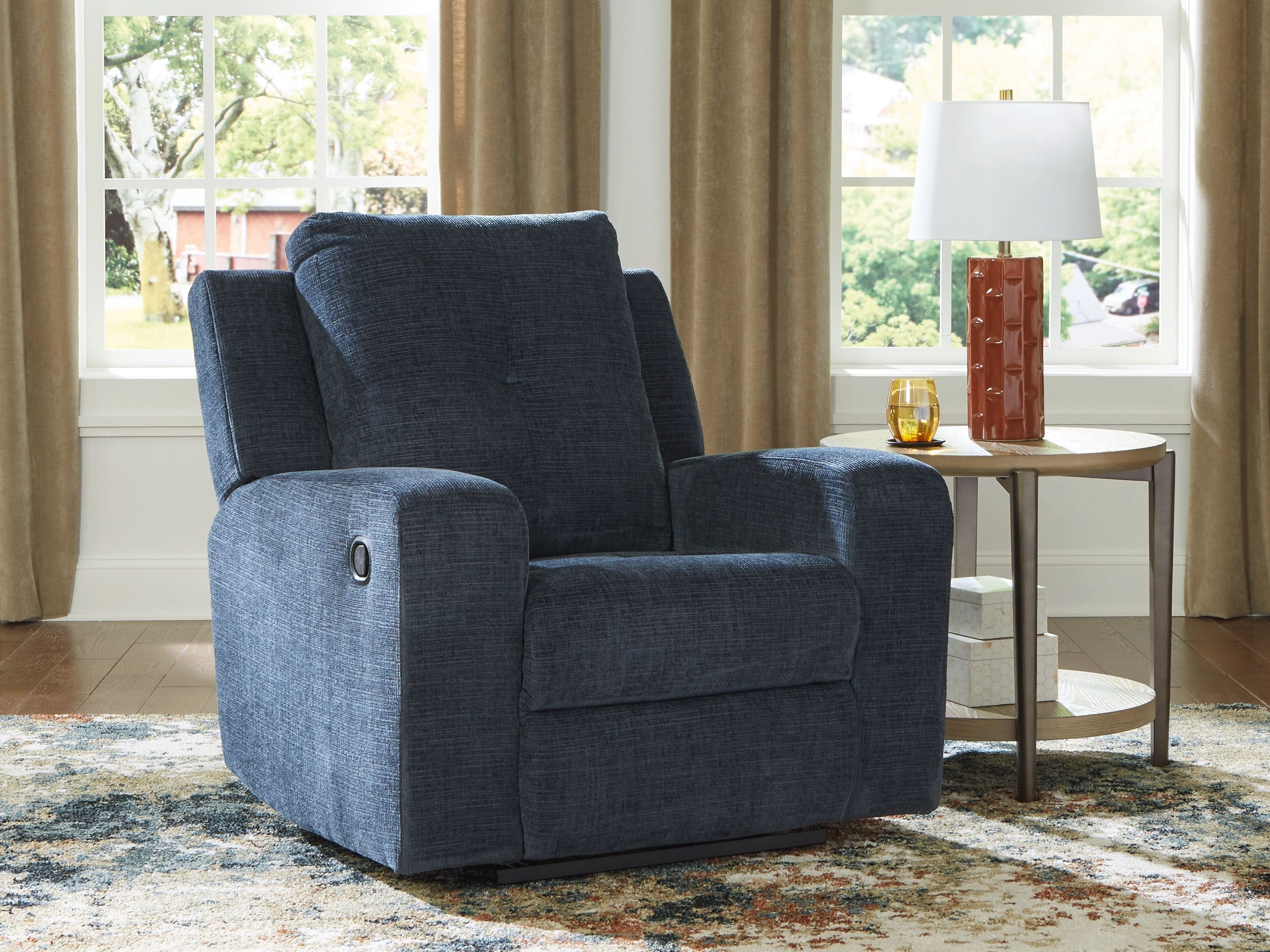 Ink blue fabric wall recliner with tall back, padded arms, and button detail on side