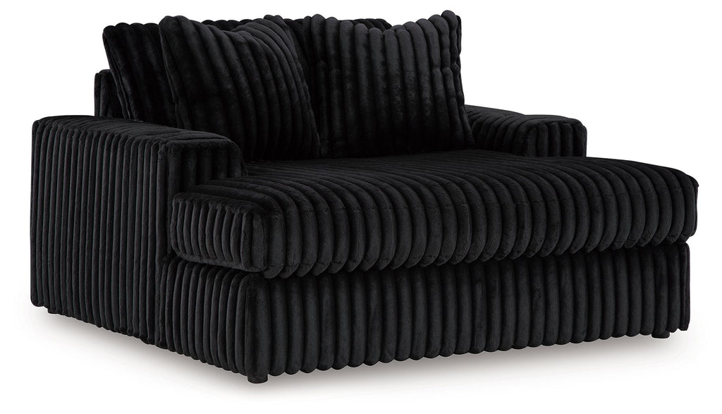 Black corded sectional chaise with rounded arm and tufted cushion seating