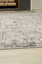 Distressed geometric rug with light off-white base and gray pattern on hardwood floor