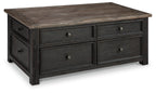 Grayish-brown lift-top cocktail table with four drawers, dark handles, and lift-up top.