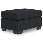 Coal gray upholstered ottoman with cushioned top and short block legs