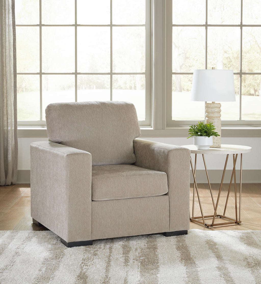 Light gray upholstered armchair with thick backrest and boxy silhouette