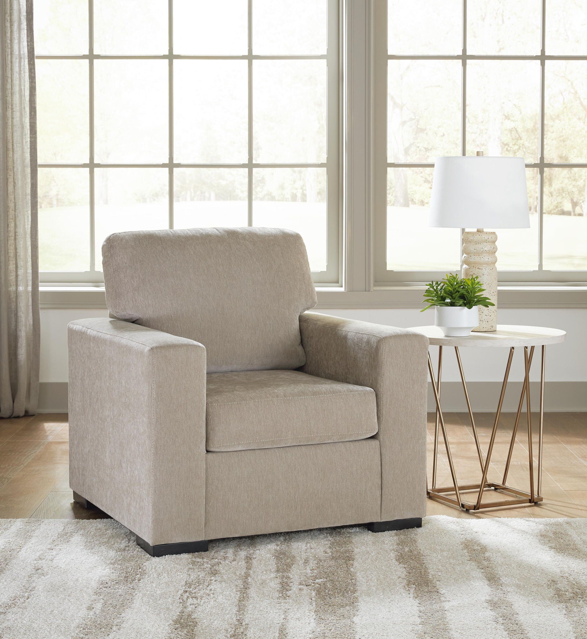 Light gray upholstered armchair with thick backrest and boxy silhouette