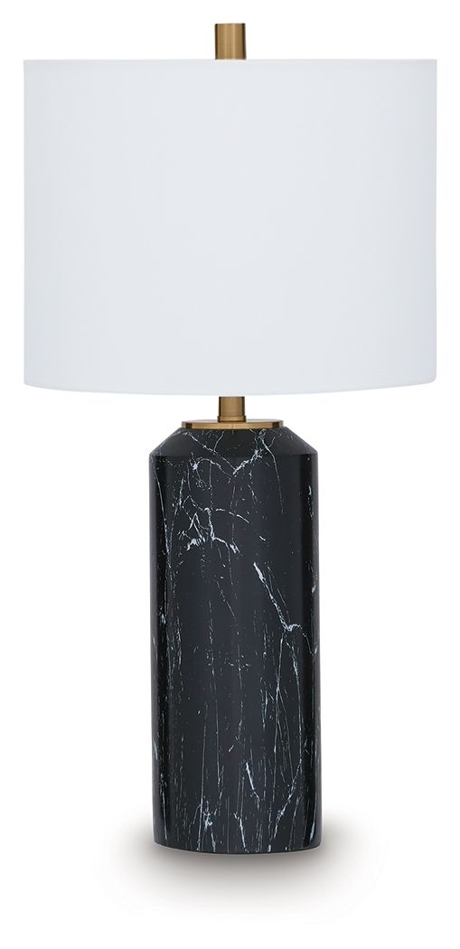 Black table lamp with white fabric shade and gold stem over black marble-style base