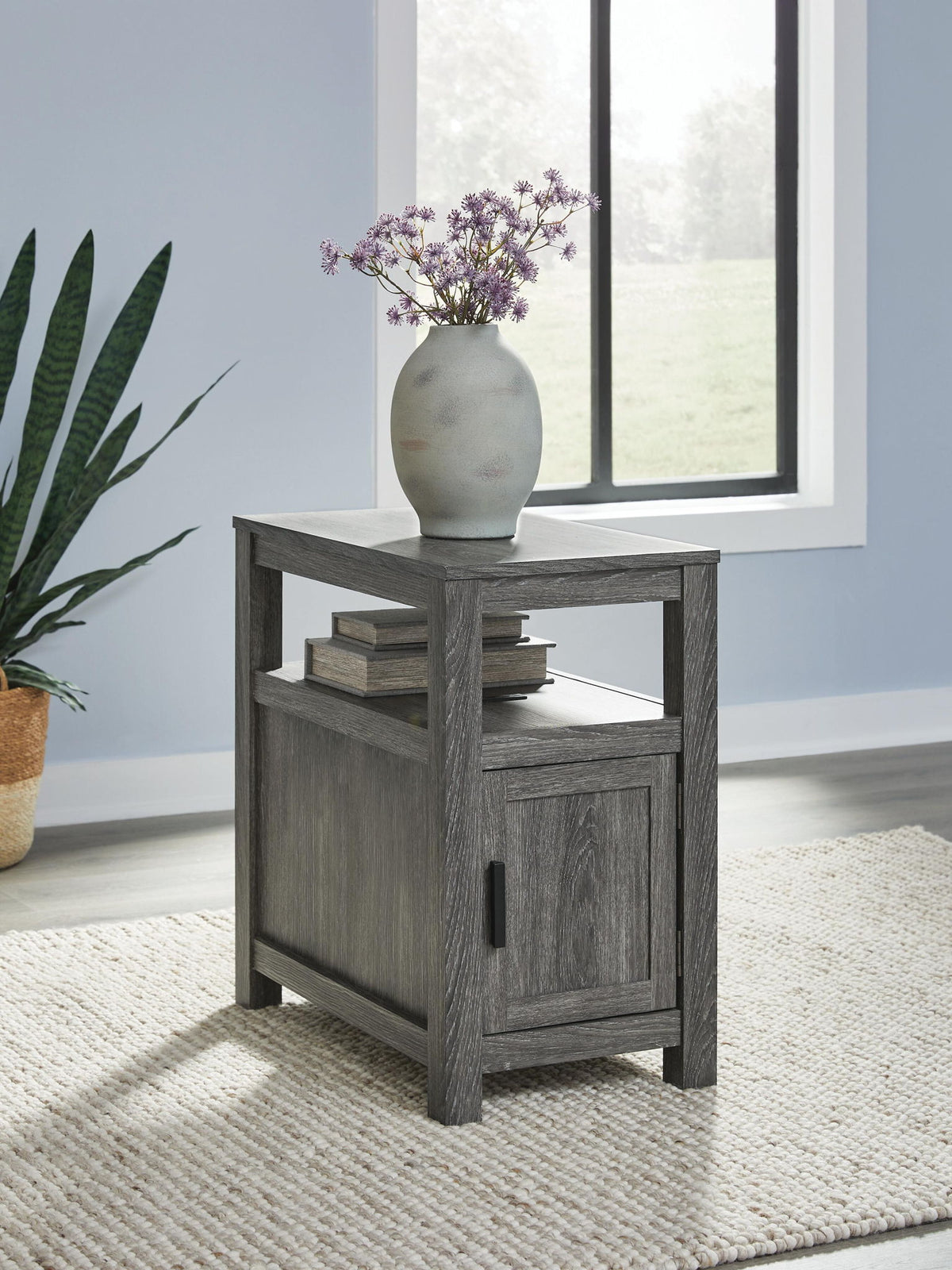 Chair side end table in gray wood with open shelf and cabinet door with black pull